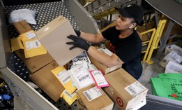 U.S. Postal Service mail clerk Quanika Davis sorts packages at the Royal Palm Processing and Distribution Center on Dec. 17, 2024 in Opa Locka, Florida.