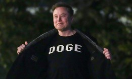 Elon Musk shows off a shirt that says "DOGE" as he walks on the South Lawn of the White House after stepping off Marine One upon arrival in Washington, DC on March 9, 2025. He has previously asserted that responses to the "five things" emails sent out by OPM were required.