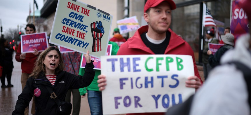 Individuals participate in a rally outside the Consumer Financial Protection Bureau on March 24, 2025, in Washington, D.C.