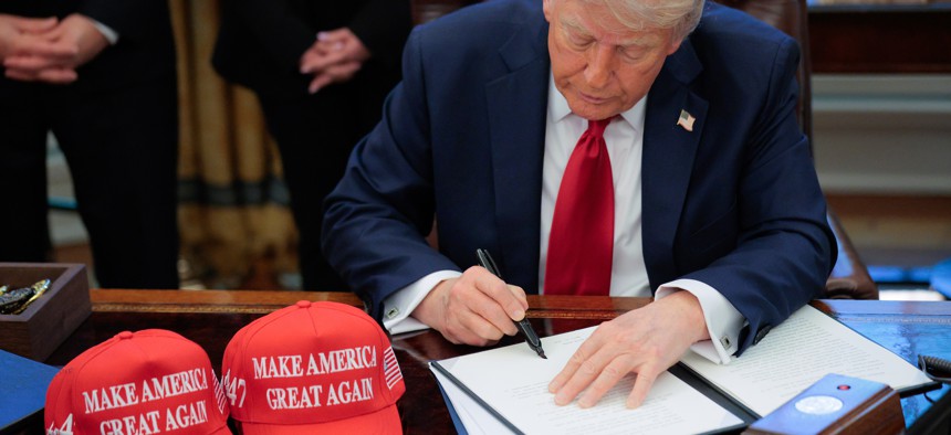 President Donald Trump signs executive orders in the Oval Office on April 23.