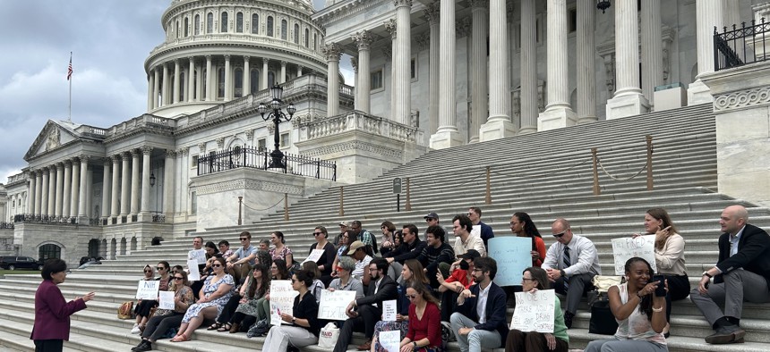 Laid off and fired federal employees listen to Rep. Judy Chu, D-Calif., on the Capitol steps.