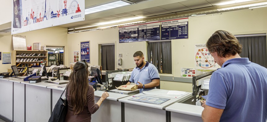 A counter clerk in a Miami Beach, Fla., post office helps customers.