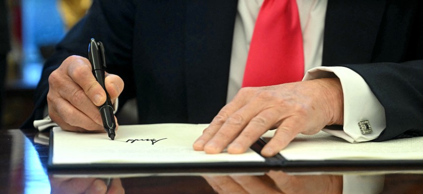 President Donald Trump signing an executive order in the Oval Office of the White House on Feb. 25, 2025.