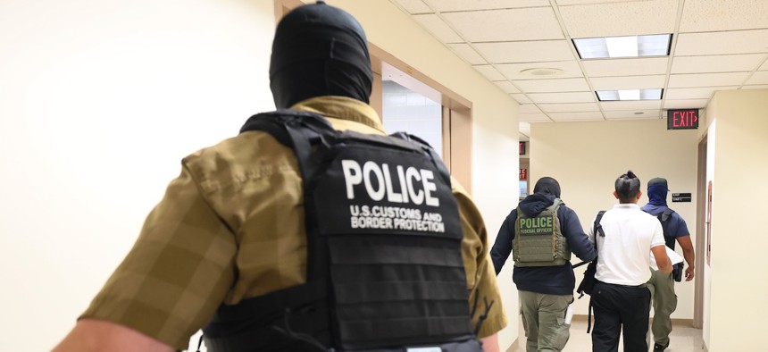 Federal agents detain a person exiting a court hearing at immigration court at the Jacob K. Javitz Federal Building in New York City on Aug. 6, 2025. The agency is eliminating the age cap for new hires to allow people older than 40 to join its force as it continues to carry out the Trump administration's mass deportation agenda.