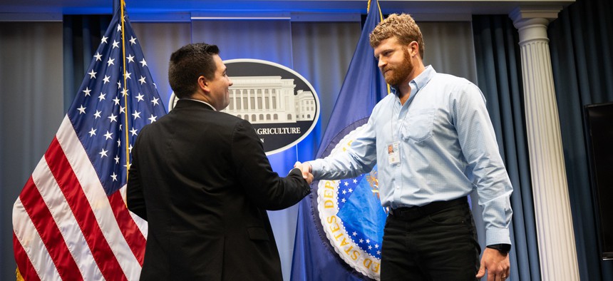 Dominic Restuccia, White House liaison, swears in Sam Berry as senior advisor on government efficiency on May 19, 2025, at the Department of Agriculture in Washington, D.C.