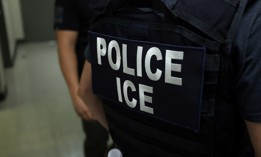 An agent of Immigration and Customs Enforcement waits in a hallway outside of a courtroom at New York Federal Plaza Immigration Court in New York on July 17, 2025. The agency now employs more than 22,000 officers and agents, up from 10,000 a year ago.
