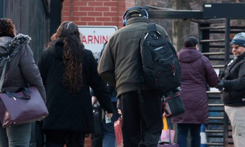 Federal employees walk to an entrance of the Navy Yard in Washington, D.C., as security checks credentials on Feb. 10, 2025, when many government workers were required to return to work in the office following a directive from President Donald Trump.