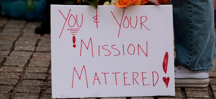 Flowers and a sign are seen as former United States Agency for International Development employees terminated after the Trump administration dismantled the agency collect their personal belongings at the USAID headquarters on Feb. 27, 2025 in Washington, D.C.
