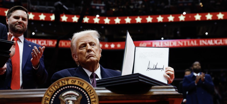 President Donald Trump holds up an executive order after signing it during an indoor inauguration parade at Capital One Arena on Jan. 20, 2025, in Washington, D.C. His administration has prioritized shrinking the federal workforce during his second term. 