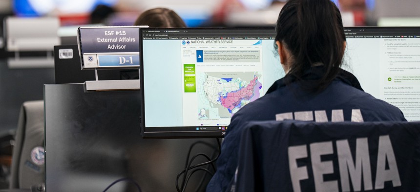  A worker in the National Response Coordination Center looks at a map of the approaching winter storm at the Federal Emergency Management Agency headquarters on Jan. 24 in Washington, D.C. The agency two days before paused some workforce reductions. 