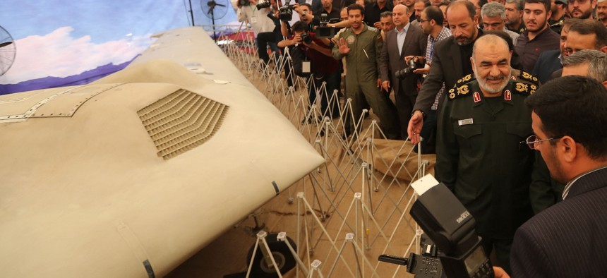 Iranian Revolutionary Guards commander Major General Hossein Salami (R) stands next to what Iran presented as an American RQ-170 Sentinel drone in Tehran, September 21, 2019.