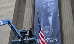 Workers install a banner featuring President Donald Trump on the facade of the Justice Department headquarters in Washington, D.C, on Feb. 19. 