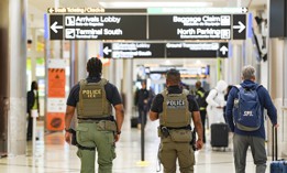 ICE agents walk around the airport as travelers navigate through Atlanta Hartsfield-Jackson International Airport on March 25, 2026 in Atlanta. The travel disruptions continue as hundreds of TSA agents quit or work without pay during a partial government shutdown. President Donald Trump deployed ICE agents to U.S. airports on Monday, with border czar Tom Homan in charge of the effort.