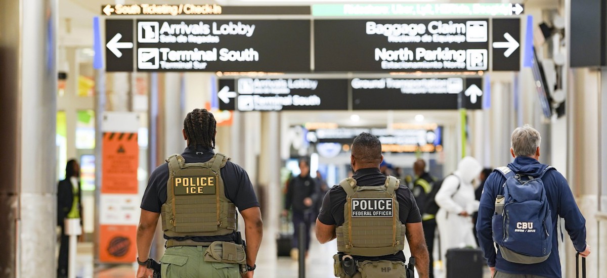 ICE agents walk around the airport as travelers navigate through Atlanta Hartsfield-Jackson International Airport on March 25, 2026 in Atlanta. The travel disruptions continue as hundreds of TSA agents quit or work without pay during a partial government shutdown. President Donald Trump deployed ICE agents to U.S. airports on Monday, with border czar Tom Homan in charge of the effort.