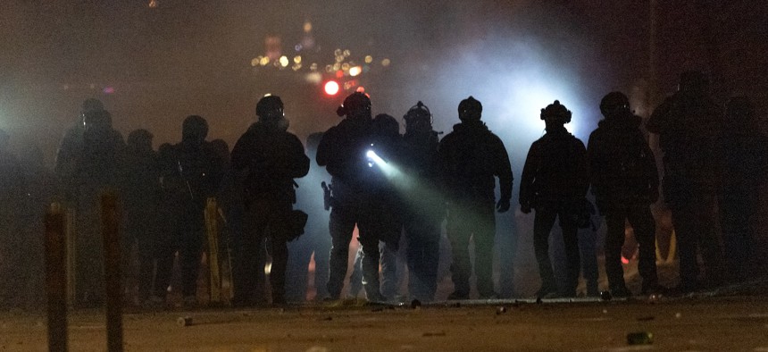 Federal agents guard a perimeter following a shooting involving an ICE agent who shot a Venezuelan man the agent said was resisting arrest, as angry residents protest the federal presence in Minneapolis on Jan. 14, 2026.