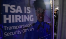 A poster promoting a career in TSA sits by a crowded TSA Checkpoint at the Philadelphia International Airport on March 28, 2026.