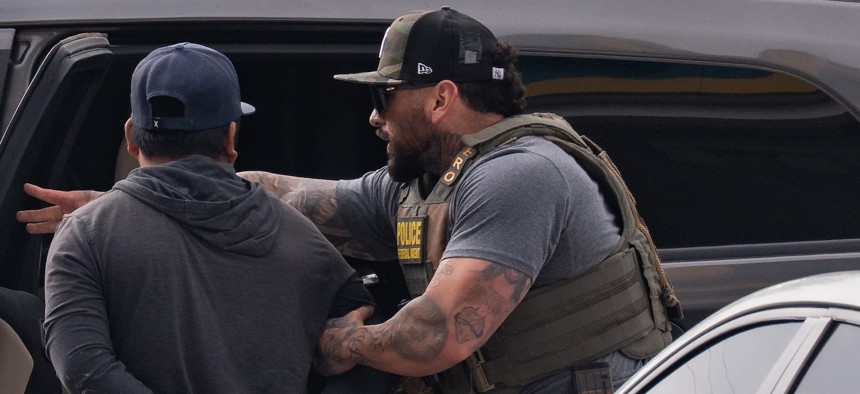 An ICE agent makes an arrest following a traffic stop made by a Department of Public Safety officer in Mustang Ridge, outside Austin, Texas, on April 16, 2026.