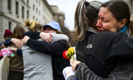 U.S. Agency for International Development staffers and supporters embrace outside of the agency's former offices on Feb. 27, 2025, in Washington, D.C. The documentary "Heist" features video of USAID employees leaving the headquarters after collecting their belongings. 