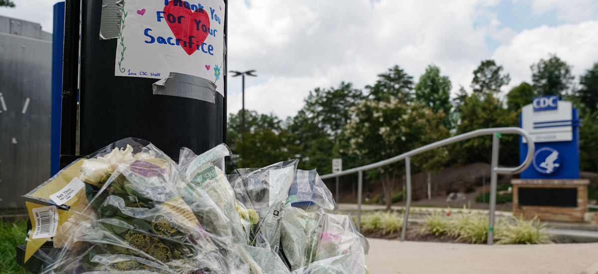 Flowers are seen below a handwritten sign outside the Centers For Disease Control headquarters in Atlanta on Aug. 9, 2025, following a shooting that left a responding police officer dead.  