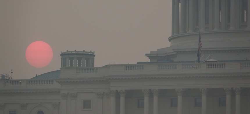The sun rises behind the U.S. Capitol building as smoke from wildfires in Canada fills the air on July 17, 2026.
