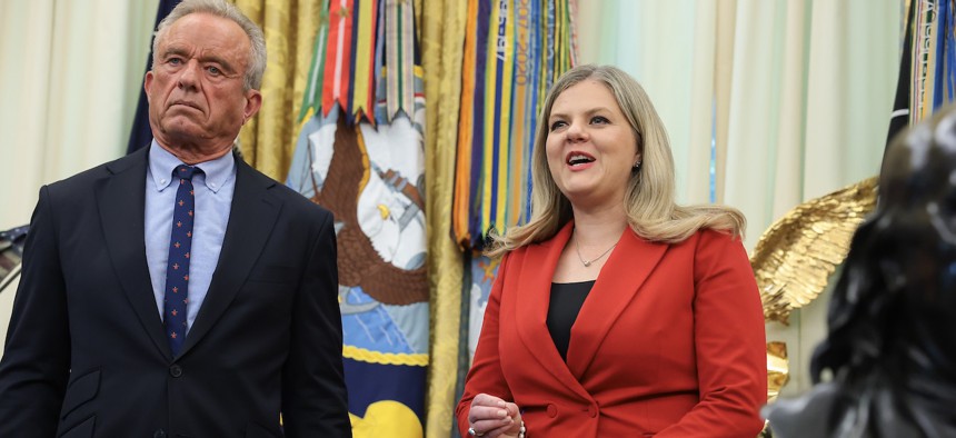 Deputy Assistant to the President for Domestic Policy Dr. Heidi Overton (right), accompanied by Health and Human Services Secretary Robert F. Kennedy Jr., speaks in the Oval Office before President Donald Trump signs an executive order calling for childhood vaccine shots to be spaced out into separate visits at the White House on Aug. 10, 2026.