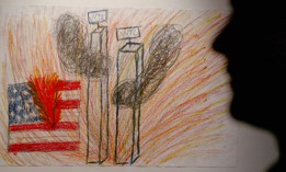 A viewer passes in front of a child's drawing portraying the terrorist attack on the World Trade Center at an art exhibition of 9/11-related children's art at the International Gallery of Childrens Art in London on Sept. 5, 2002. 