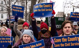 People hold signs during a "Save the Civil Service" rally outside the U.S. Capitol on Feb. 11, 2025. A new survey found that 44% of respondents said they trusted civil servants. 