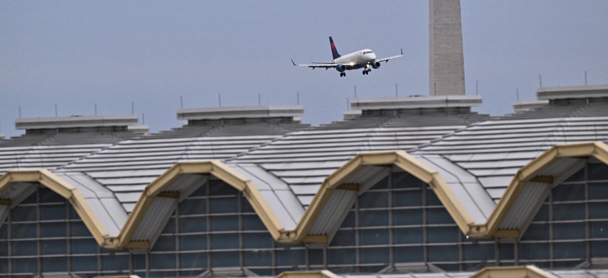 A commercial jet approaches the runway at Ronald Reagan International Airport near the Washington Monument and the airport terminal in Arlington, Va., on Feb. 2, 2025.