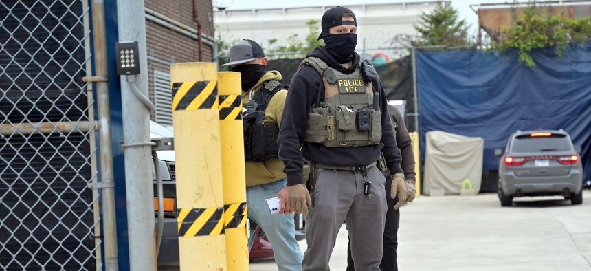  An Immigration and Customs Enforcement (ICE) officer wearing a tactical vests, body camera and face covering stands guard inside the perimeter gate of an ICE processing facility on Sept. 25, 2026, as demonstrators gather outside for an anniversary rally marking one year since the September 2025 protests during Operation Midway Blitz in Broadview, Ill.