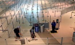 A TSA agent speaks to travelers passing through an empty security queue at Love Field airport in Dallas on Thursday, amid concerns related to the coronavirus pandemic. 
