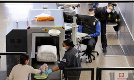 TSA agents wear masks as they screen passengers at Seattle-Tacoma International Airport on April 15. 